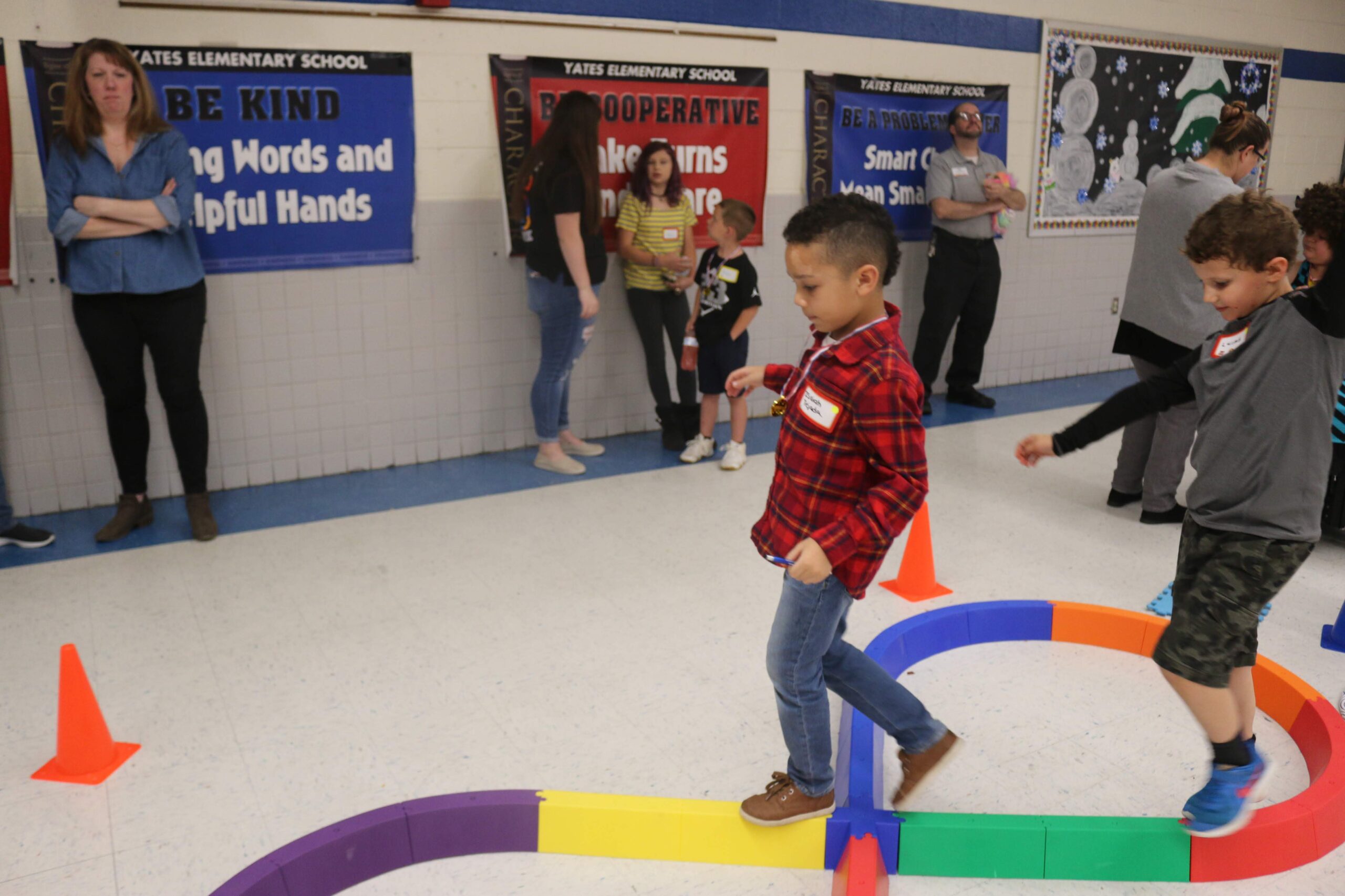 kids doing obstacle course as parents watch