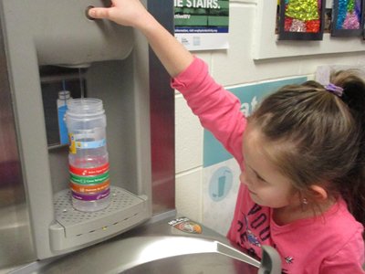 Girl using water fountain.