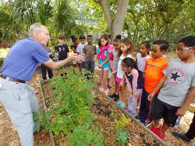 Teacher Showing Kids Garden Plants