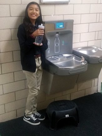 Girl Filling Water Bottle at Fountain