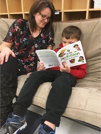 Kid Reading Book with Adult